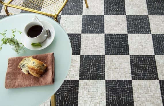 Roman Check, a hand-chopped stone mosaic, shown in tumbled Nero Marquina and Whitewood, is part of the Heritage Collection by New Ravenna.